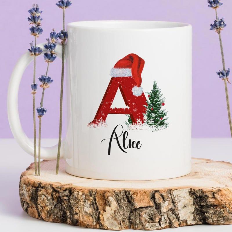 Tailorly White Ceramic 11 oz Mug - Alice Vibrant Red Festive Letter Wearing Santa Hat Beside Snowy Tree Alphabet