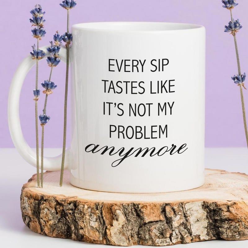 Tailorly White Ceramic 11 oz Mug - Every Sip Tastes Like Its Not My Problem Anymore Minimalist White Ceramic Cup Resting On Natural Wooden Base Mug
