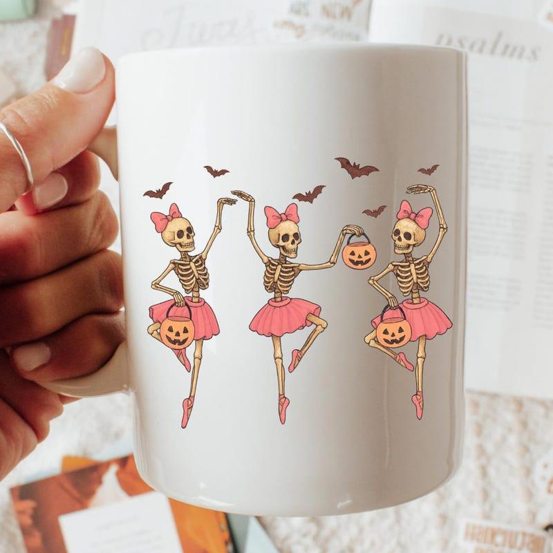 Tailorly White Ceramic 11 oz Mug - Dancing Ballerina Figures Wearing Pink Tutus Holding Spooky Halloween Pumpkin Buckets Skeleton