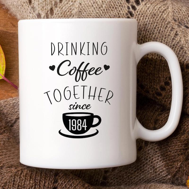 Tailorly White Ceramic 11 oz Mug - Drinking Coffee Together Since 1984 Minimalist Style Featuring Small Hearts Surrounding A Stylized Steaming Mug