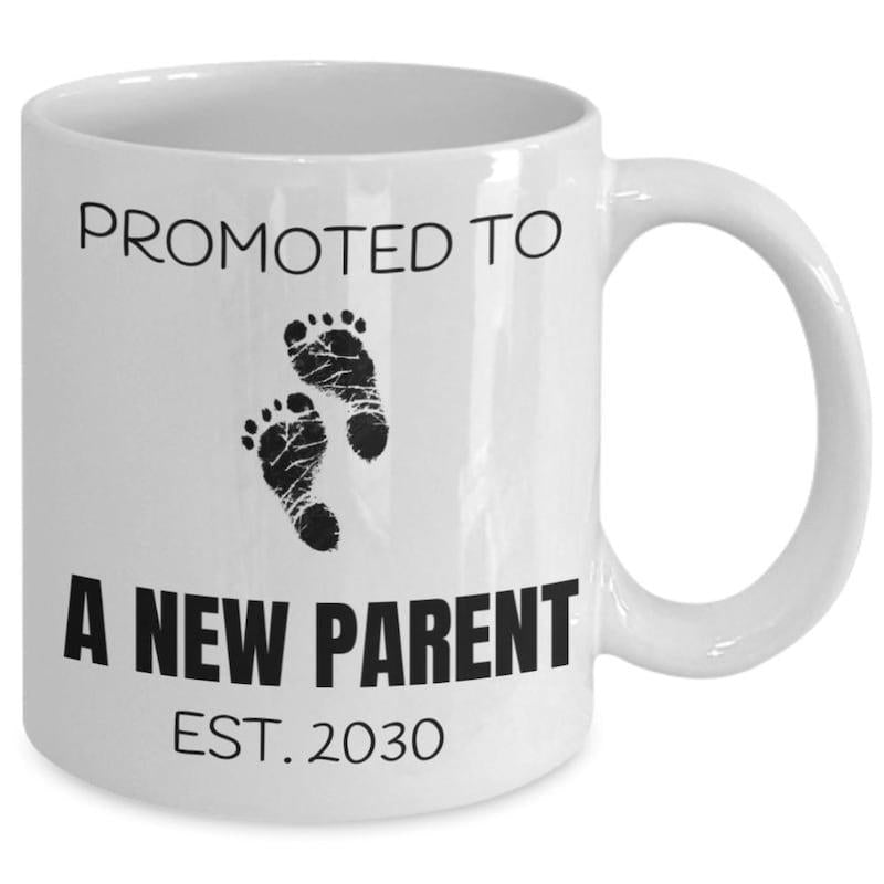 Tailorly White Ceramic 11 oz Mug - Promoted To A New Parent Est 2030 Minimalist Black Ink Baby Feet Prints Centered Between Bold Modern Typography Footprints