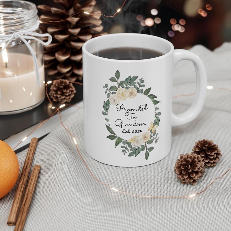 Tailorly White Ceramic 11 oz Mug - Promoted To Grandma Est 2024 Delicate Floral Wreath With Green Leaves And Pale Yellow Flowers Mug