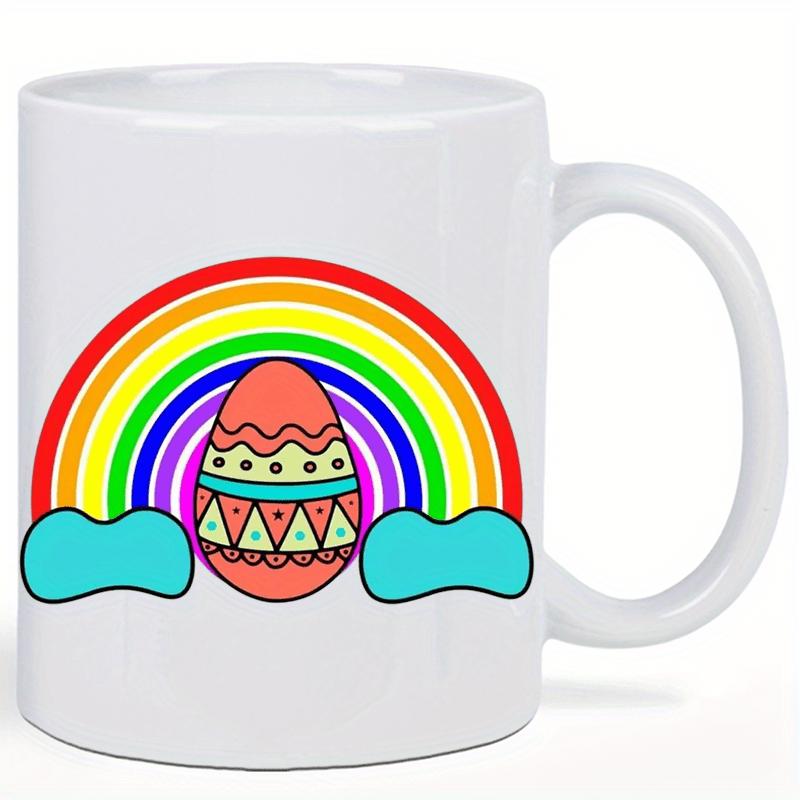 Tailorly White Ceramic 11 oz Mug - Vibrant Colorful Arched Rainbow With Stylized Clouds Surrounding A Patterned Festive Egg