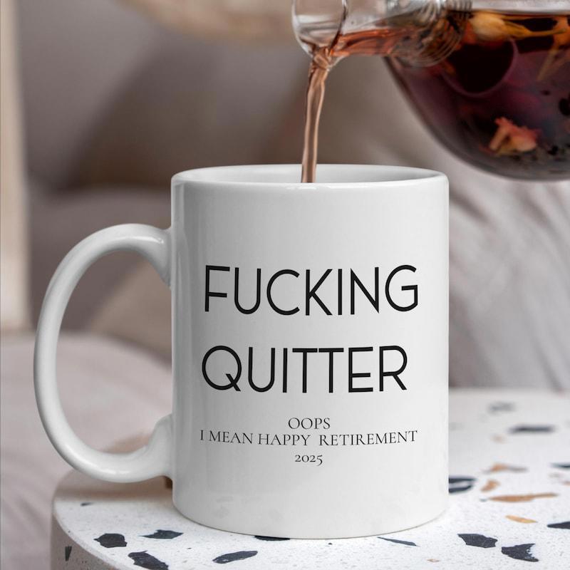 Tailorly White Ceramic 11 oz Mug - Fucking Quitter Oops I Mean Happy Retirement 2023 Minimalist White Ceramic Cup Standing On Stone Table With Tea Pouring Mug