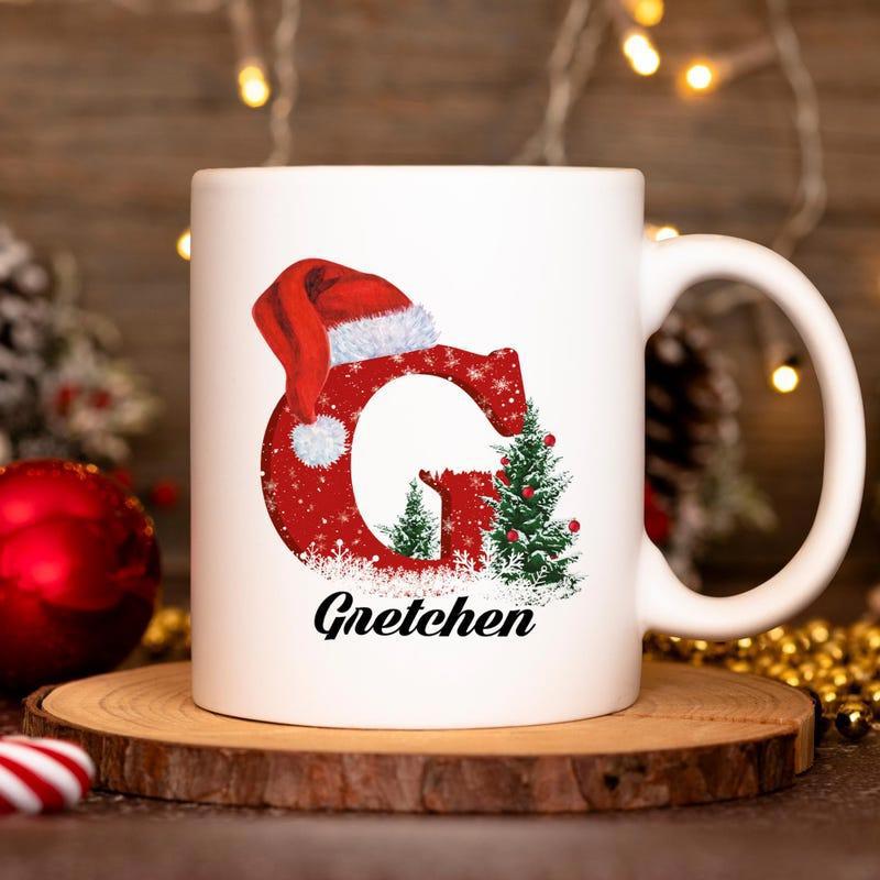 Tailorly White Ceramic 11 oz Mug - Gretchen Festive Red Letter G Wearing Santa Hat Beside Snowy Pine Trees Letter