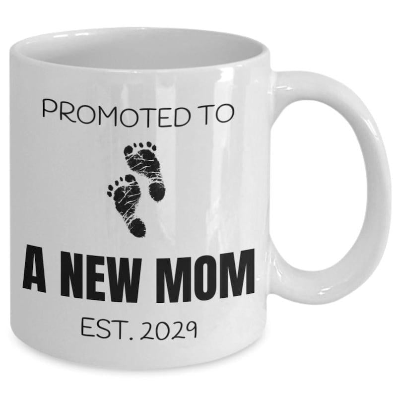 Tailorly White Ceramic 11 oz Mug - Promoted To A New Mom Est 2029 Minimalist Black Ink Style Baby Footprints Printed On Smooth Ceramic Surface Mug
