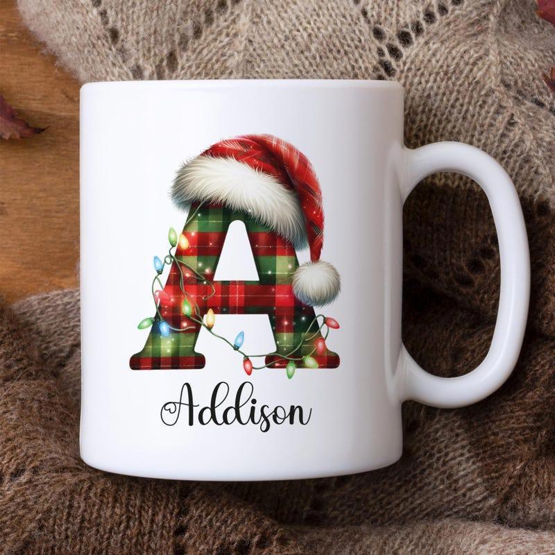 Tailorly White Ceramic 11 oz Mug - Addison Festive Red And Green Plaid Pattern Wearing A Fluffy Red Santa Hat Letter
