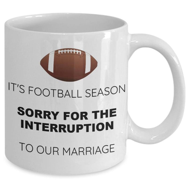 Tailorly White Ceramic 11 oz Mug - Its Football Season Sorry For The Interruption To Our Marriage Classic Brown American Football Positioned Centrally Above Simple