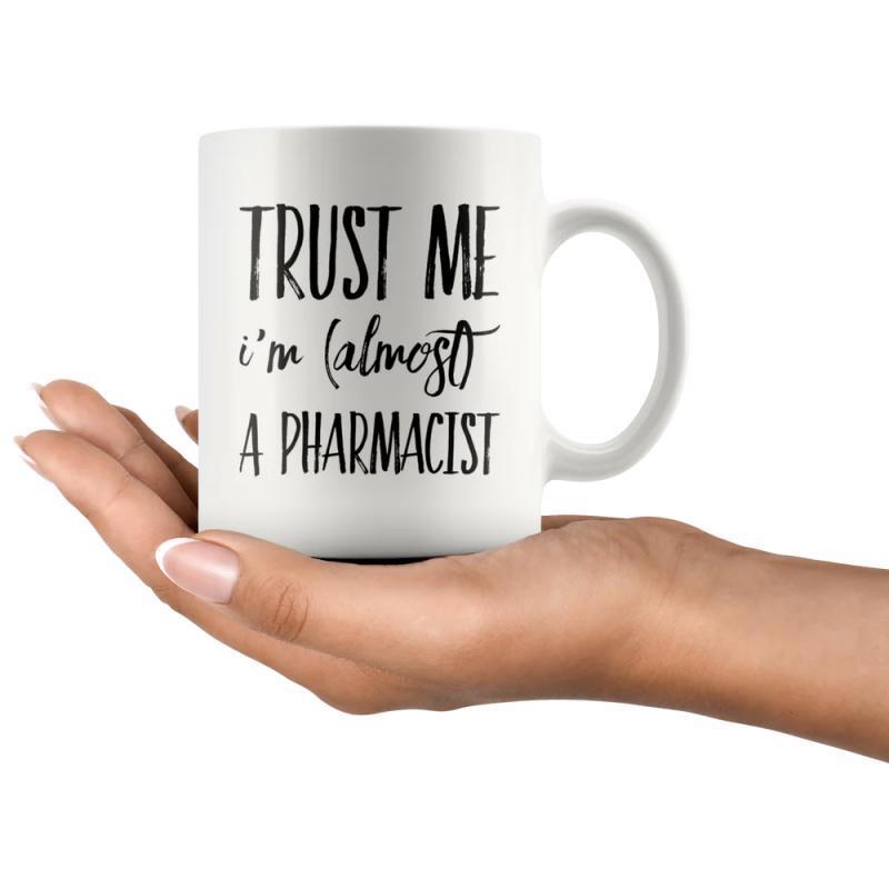 Tailorly White Ceramic 11 oz Mug - Trust Me Im Almost A Pharmacist White Ceramic Vessel Held By A Gentle Human Hand Elegant Simple Mug
