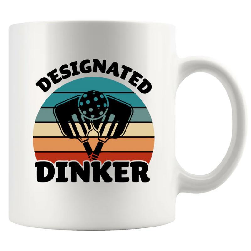 Tailorly White Ceramic 11 oz Mug - Designated Dinker Retro Style Sunset With Crossed Equipment And A Perforated Pickleball