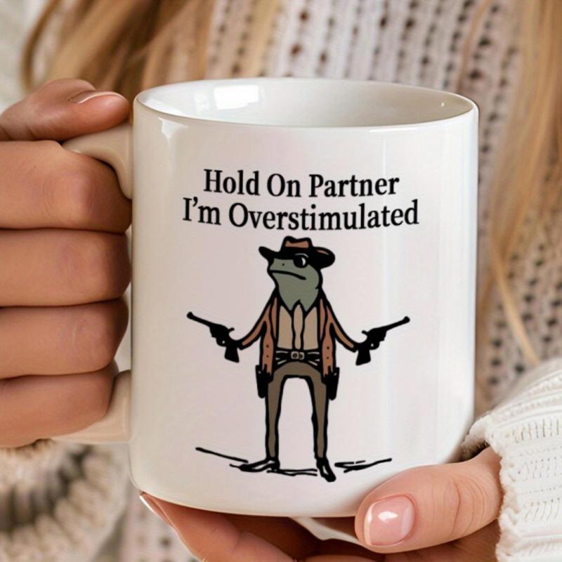 Tailorly White Ceramic 11 oz Mug - Hold On Partner Im Overstimulated Quirky Cartoon Cowboy Wearing Western Gear Holding Two Revolvers Standing Frog
