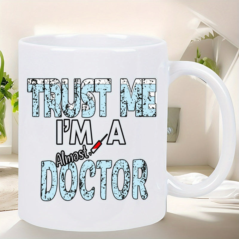 Tailorly White Ceramic 11 oz Mug - Trust Me Im A Almost Doctor Large Blue Textured Letters Featuring A Small Red Medical Syringe Among Bold Typography Mug
