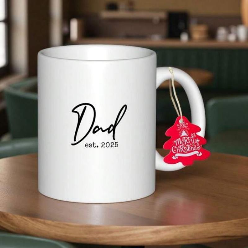 Tailorly White Ceramic 11 oz Mug - Dad Est 2025 Merry Christmas Minimalist White Ceramic Featuring Simple Black Script Lettering On Table Mug