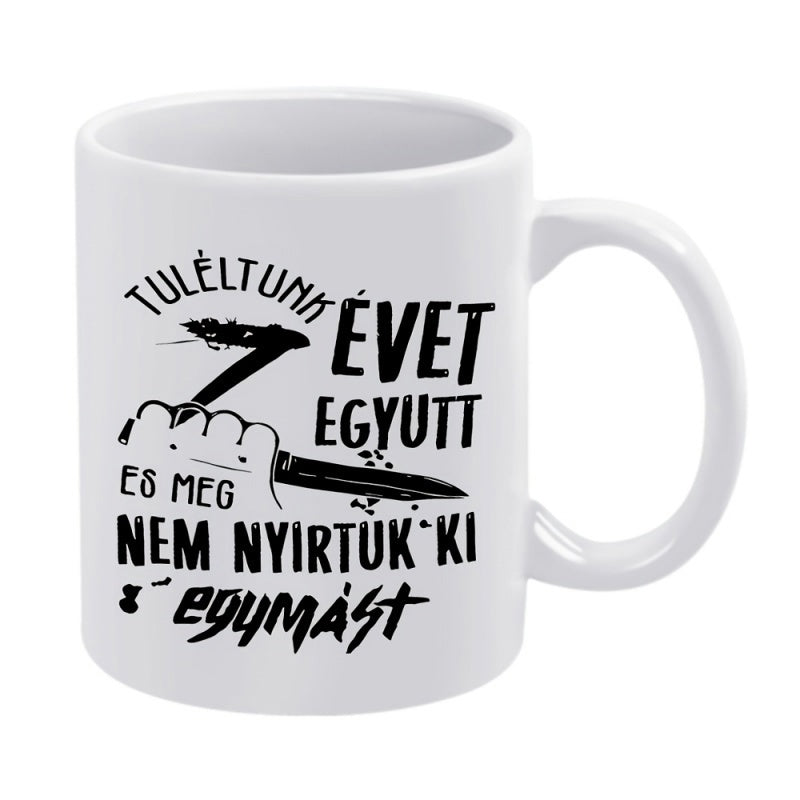 Tailorly White Ceramic 11 oz Mug - Holding A Sharp Kitchen Knife With A Stylized Number Seven Hand