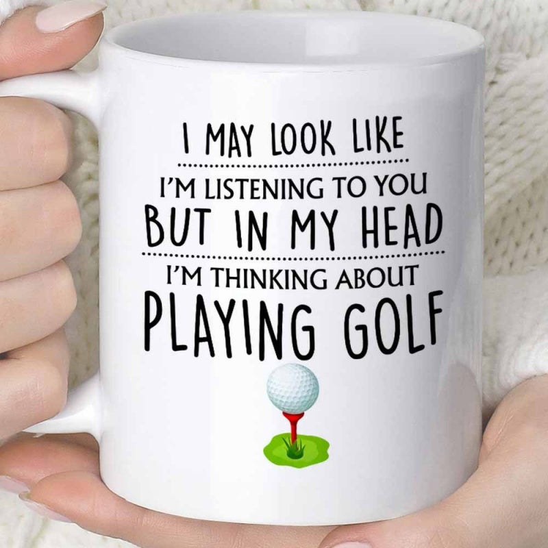 Tailorly White Ceramic 11 oz Mug - I May Look Like Im Listening To You But In My Head Im Thinking About Playing Golf Simple Textured White Ball Resting On A Red