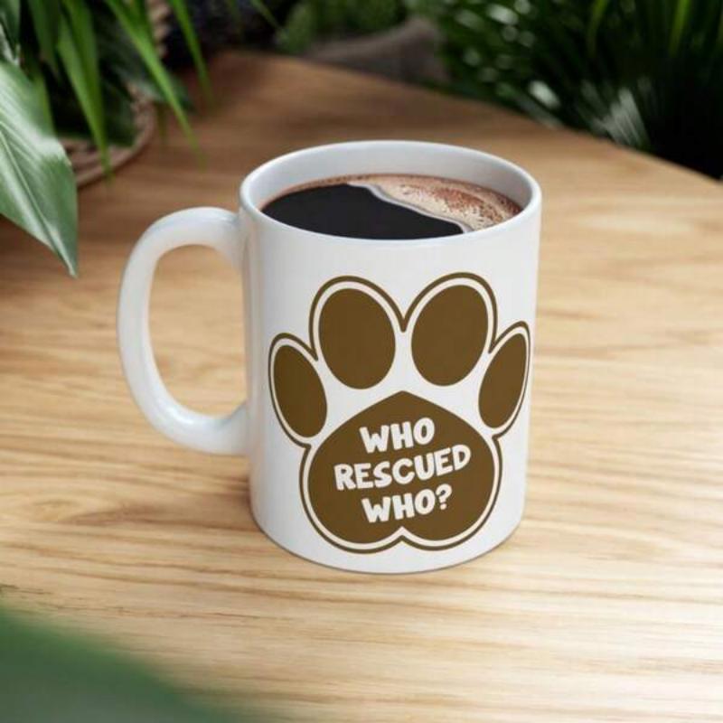 Tailorly White Ceramic 11 oz Mug - Who Rescued Who Simple Brown Paw Silhouette Resting On White Ceramic Glossy Surface Paw Print