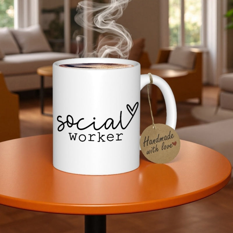 Tailorly White Ceramic 11 oz Mug - Social Worker Handmade With Love Minimalist Ceramic Vessel With Rising Steam Sitting On Vibrant Orange Circular Table Mug