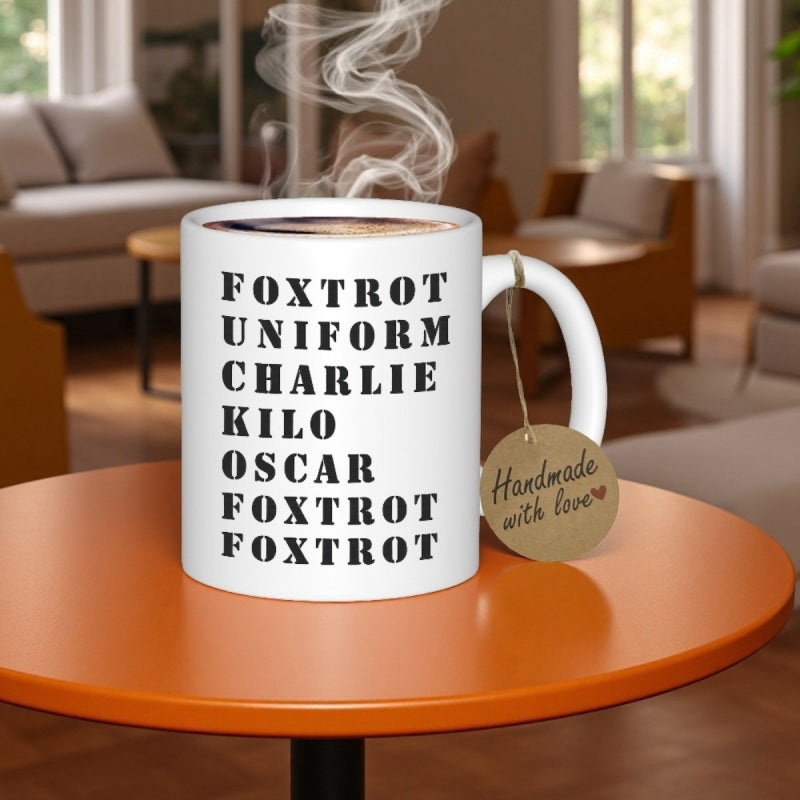 Tailorly White Ceramic 11 oz Mug - Foxtrot Uniform Charlie Kilo Oscar Foxtrot Foxtrot Classic Emitting Gentle Steam Resting On Orange Table Mug
