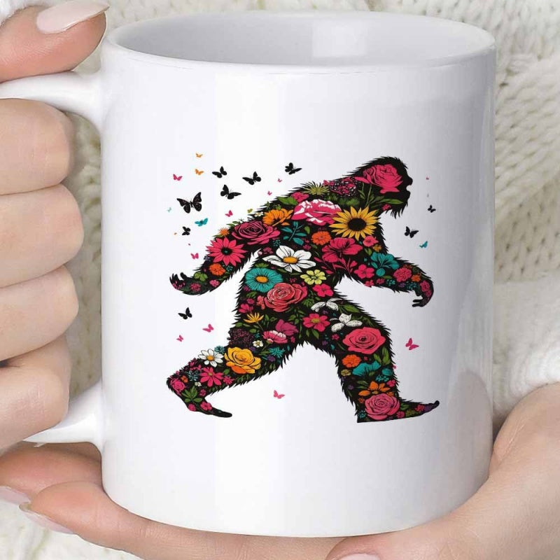 Tailorly White Ceramic 11 oz Mug - Floral Silhouette Walking Through A Garden With Colorful Butterflies Around Sasquatch