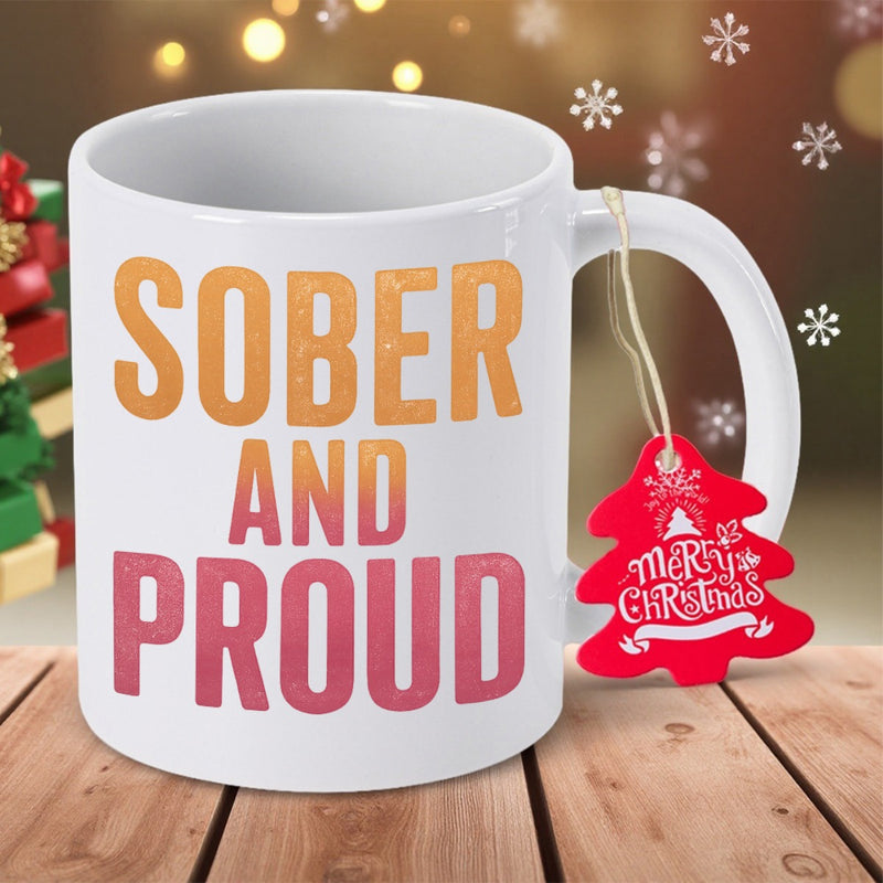 Tailorly White Ceramic 11 oz Mug - Sober And Proud Merry Christmas Bold Vibrant Gradient Lettering Accompanied By A Festive Tree Shaped Tag Mug