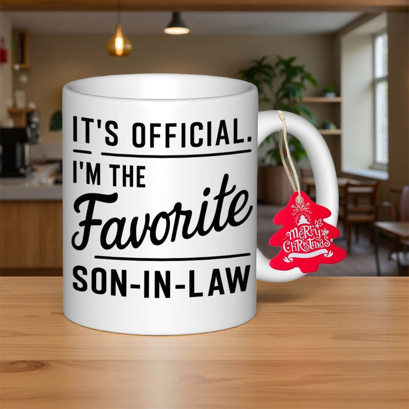 Tailorly White Ceramic 11 oz Mug - Its Official Im The Favorite Son In Law White Ceramic Vessel With Bold Black Typography Resting On Wooden Surface Mug