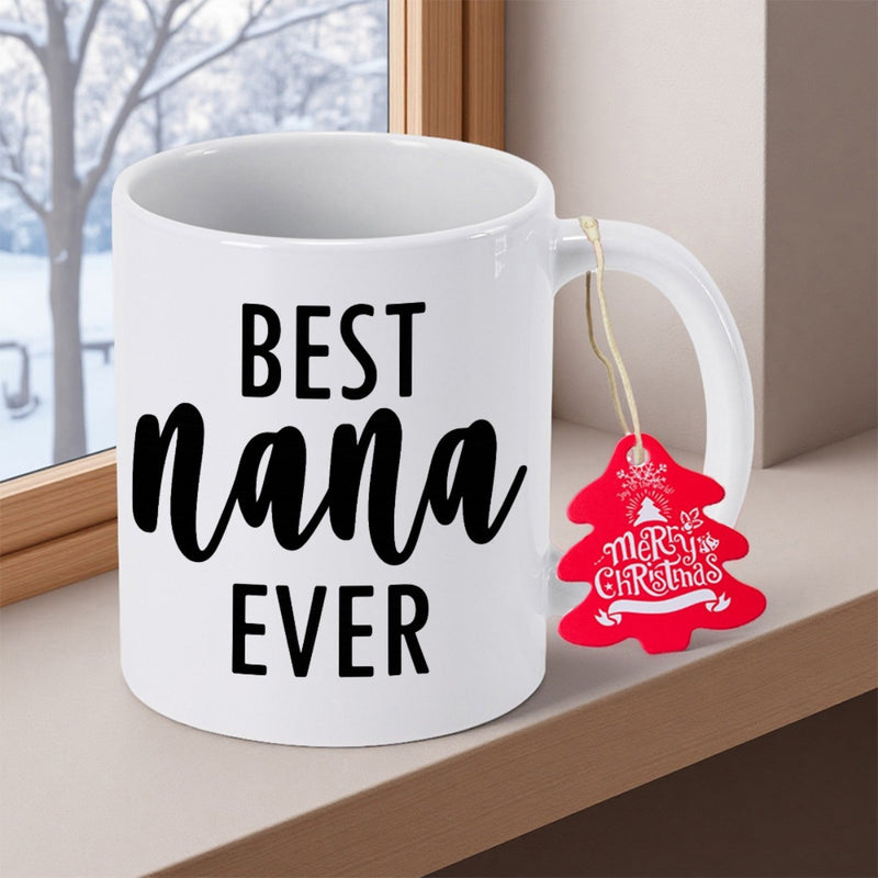 Tailorly White Ceramic 11 oz Mug - Best Nana Ever Merry Christmas White Ceramic Cup Resting Near Window With Festive Red Tree Tag Mug