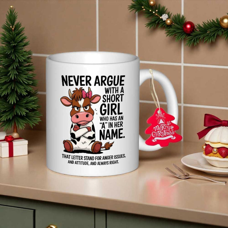 Tailorly White Ceramic 11 oz Mug - Never Argue With A Short Girl Who Has An A In Her Name Grumpy Cartoon Heifer With Pink Bow Sitting On Flat Surface Cow