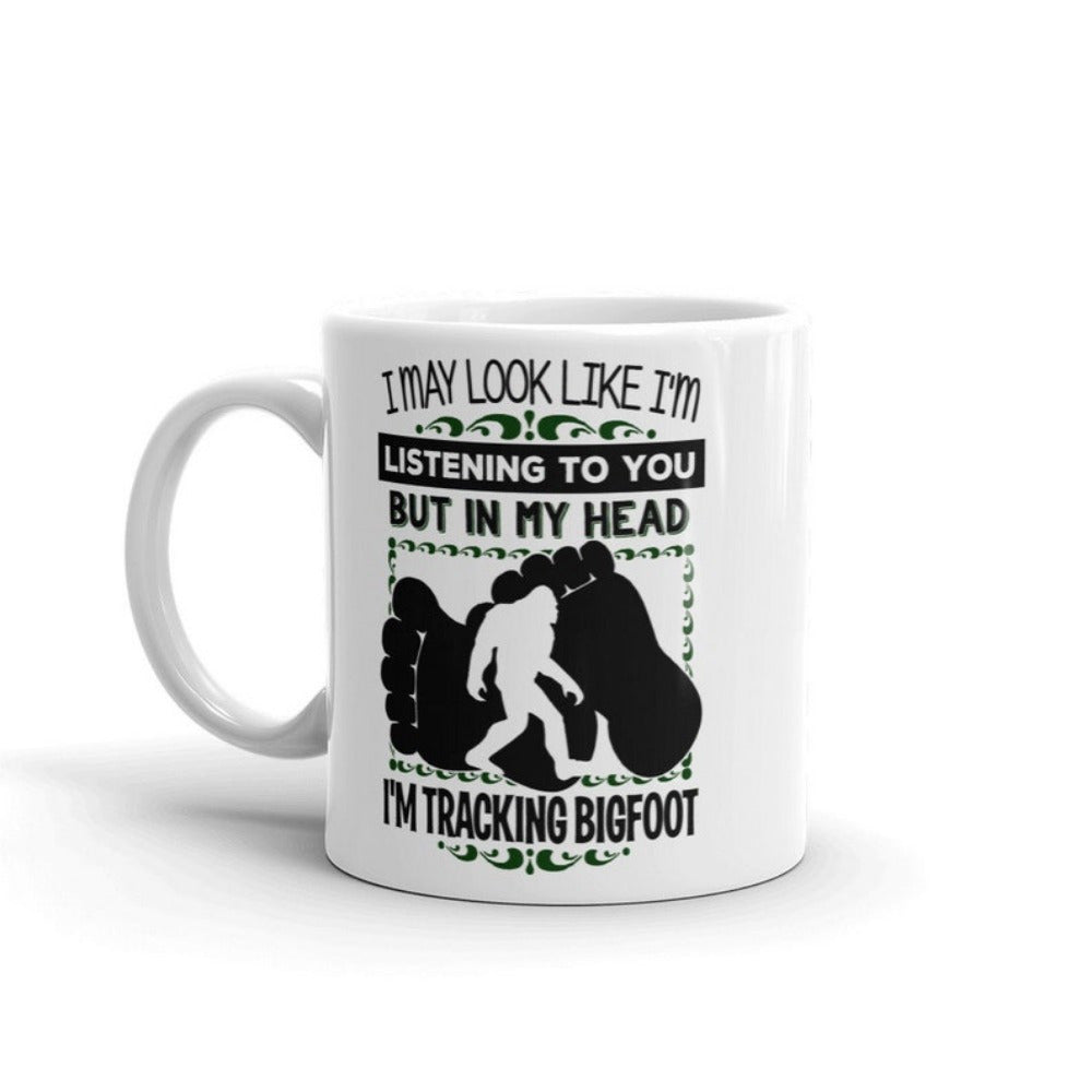 Tailorly White Ceramic 11 oz Mug - I May Look Like I'm Listening To You But In My Head I'm Tracking Bigfoot Walking Silhouette Set Between Two Large Dark Textured