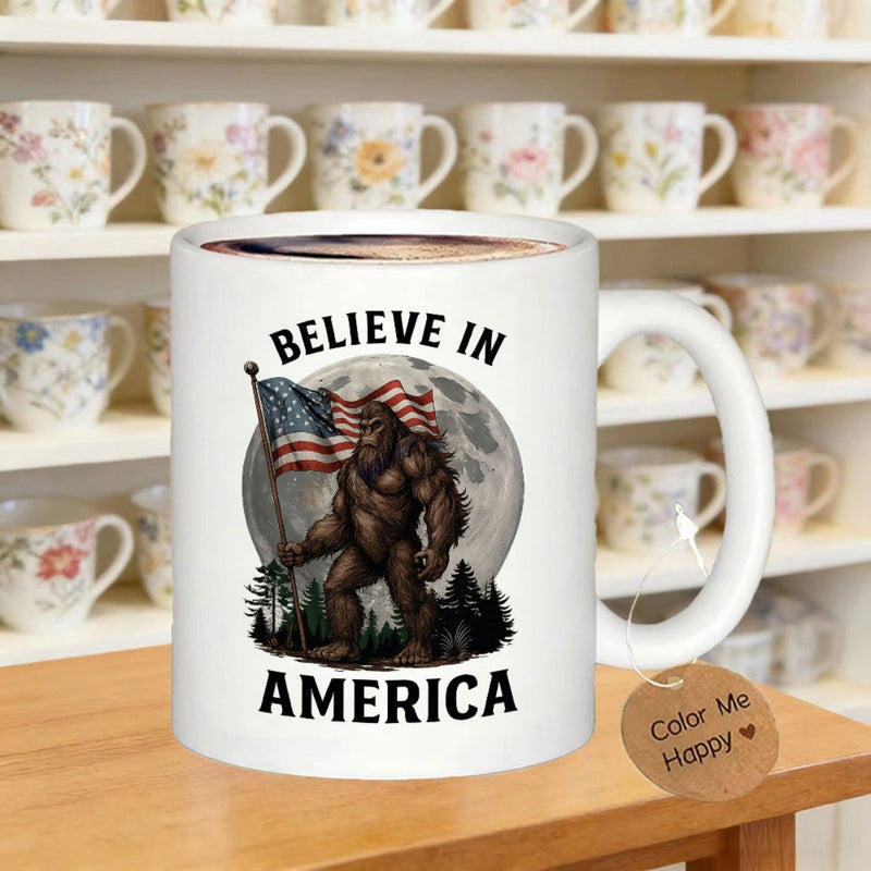 Tailorly White Ceramic 11 oz Mug - Believe In America Legendary Sasquatch Holding American Flag Standing Before A Giant Glowing Moon Sasquatch