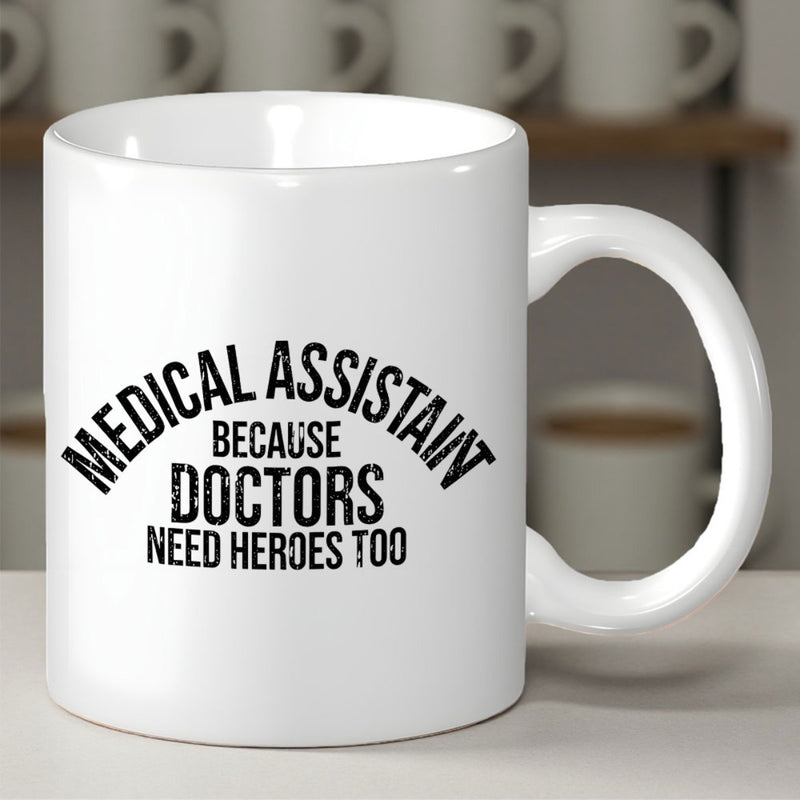 Tailorly White Ceramic 11 oz Mug - Medical Assistant Because Doctors Need Heroes Too Bold Distressed Black Vintage Lettering Arranged In Arched Layout Sign