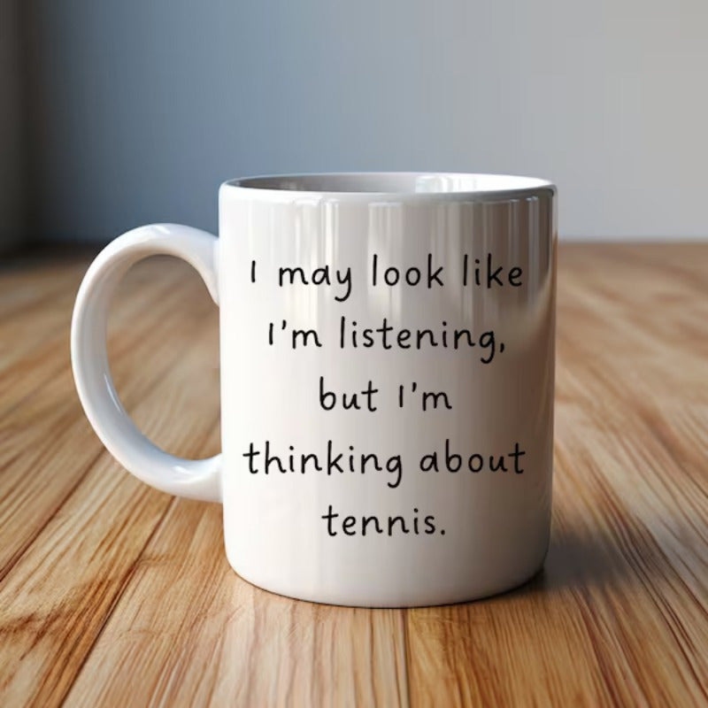 Tailorly White Ceramic 11 oz Mug - I May Look Like I'm Listening But I'm Thinking About Tennis Simple Handwritten Typography Centered On A Clean Polished Surface