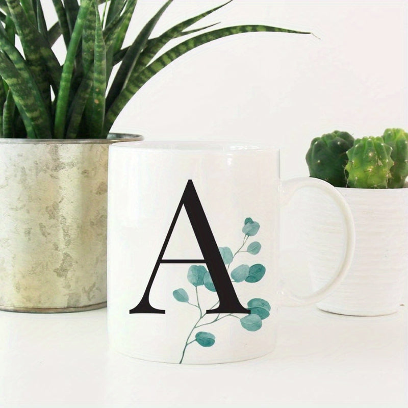 Tailorly White Ceramic 11 oz Mug - A Minimalist Modern Style Featuring Delicate Green Eucalyptus Leaves Behind A Bold Serif Letter