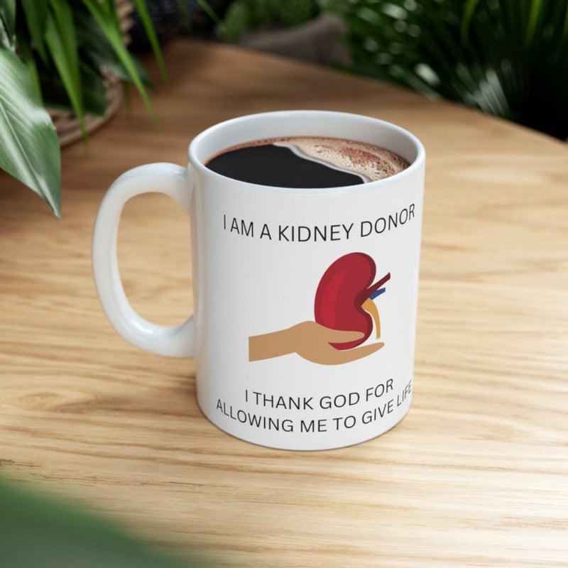Tailorly White Ceramic 11 oz Mug - I Am A Kidney Donor I Thank God For Allowing Me To Give Life Hand Supporting A Stylized Red Anatomical Kidney Against White