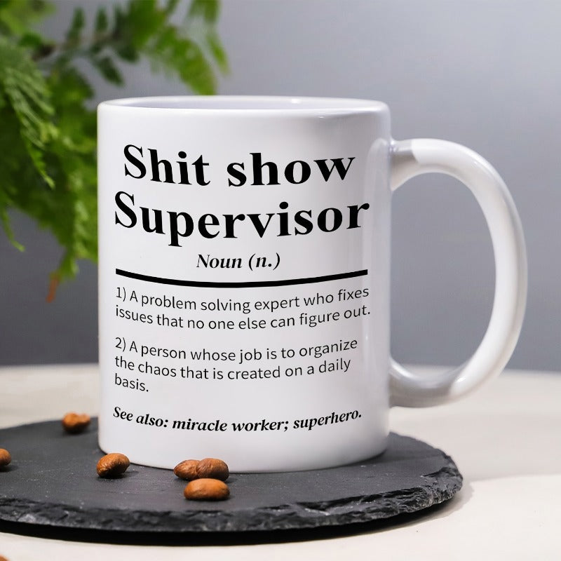 Tailorly White Ceramic 11 oz Mug - Shit Show Supervisor Resting On Black Stone Coaster With Coffee Beans Mug