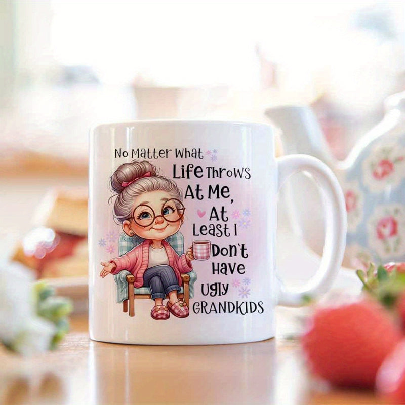Tailorly White Ceramic 11 oz Mug - No Matter What Life Throws At Me At Least I Don't Have Ugly Grandkids Smiling Cartoon Grandmother Sitting In A Chair Holding A