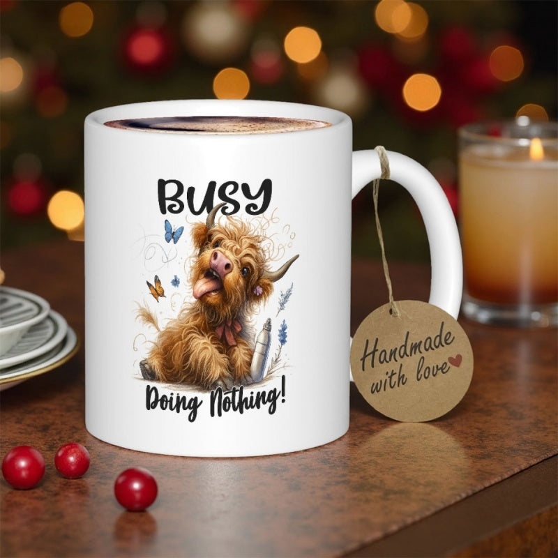Tailorly White Ceramic 11 oz Mug - Busy Doing Nothing Shaggy Brown Highland Calf Sitting Among Butterflies And Grass Cow