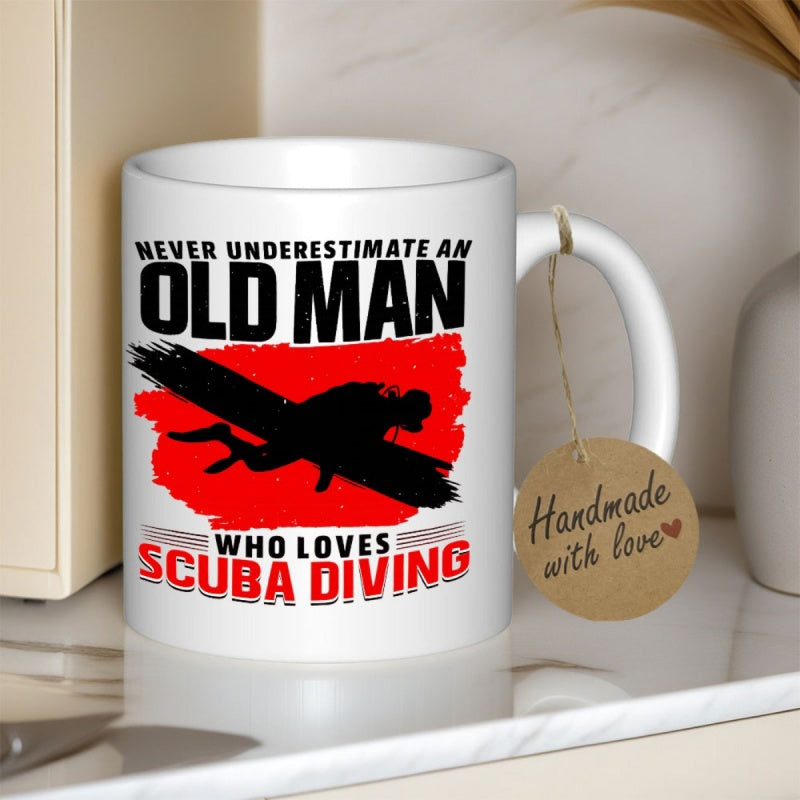 Tailorly White Ceramic 11 oz Mug - Never Underestimate An Old Man Who Loves Scuba Diving Dark Silhouette Of A Swimmer Moving Through Vibrant Red Painted Strokes