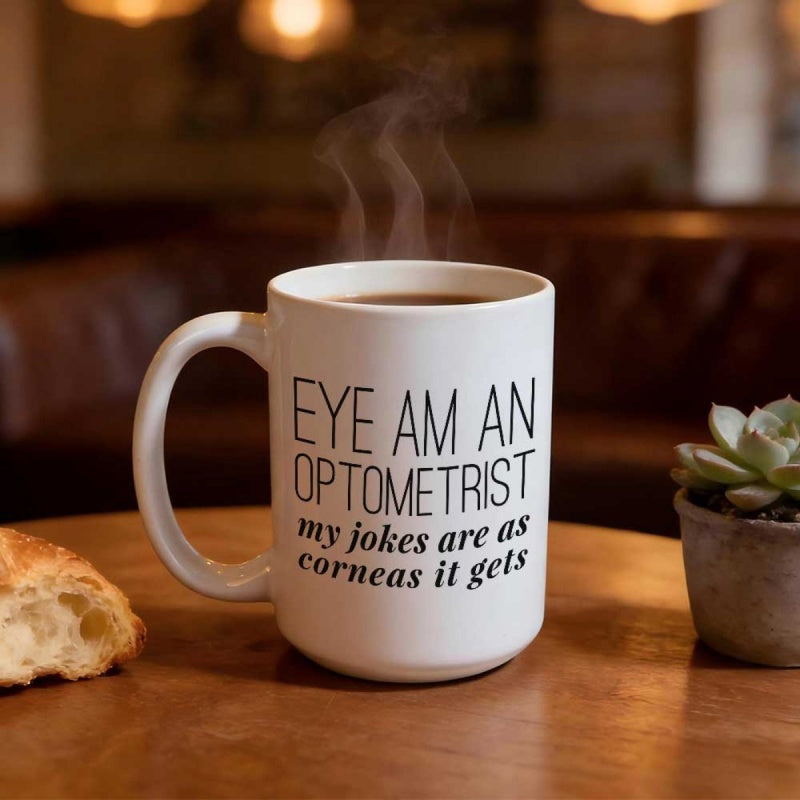 Tailorly White Ceramic 11 oz Mug - Eye Am An Optometrist My Jokes Are As Corneas It Gets Simple White Ceramic Vessel Holding Steaming Coffee On Wooden Table