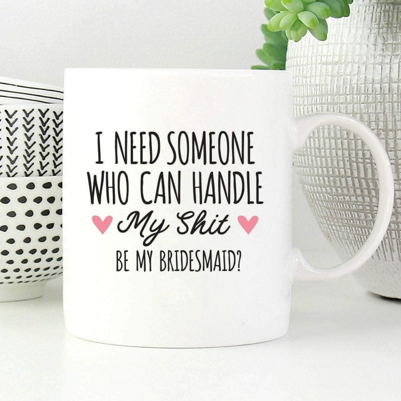 Tailorly White Ceramic 11 oz Mug - I Need Someone Who Can Handle My Shit Be My Bridesmaid Featuring Script Text Flanked By Delicate Pink Hearts On White Background