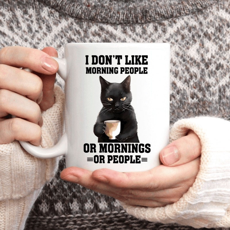 Tailorly White Ceramic 11 oz Mug - I Don't Like Morning People Or Mornings Or People Grumpy Furry Black Feline Sitting While Holding Warm Coffee Mug With Paws Cat