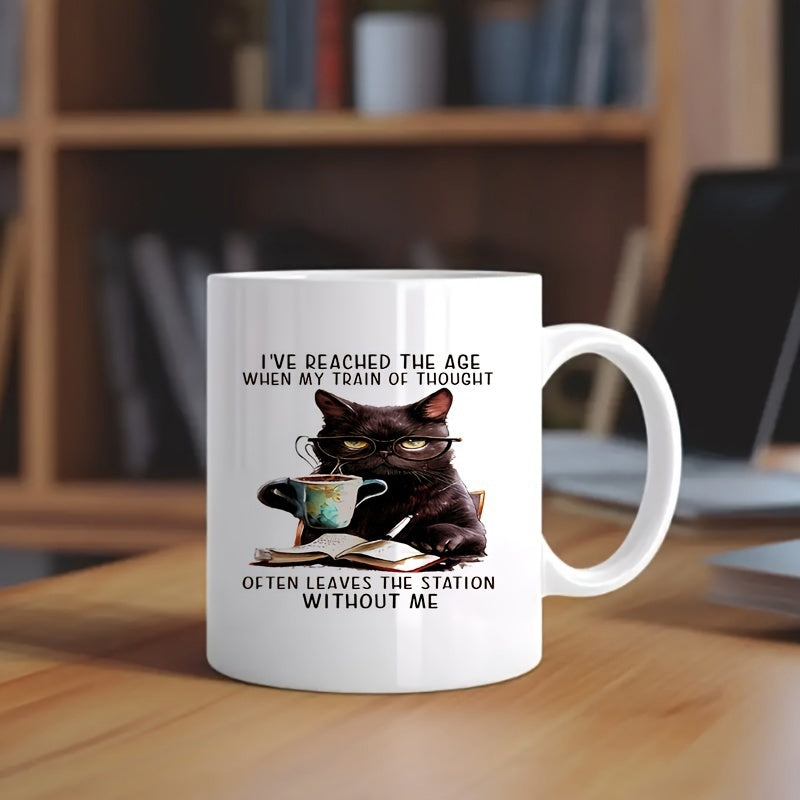 Tailorly White Ceramic 11 oz Mug - Ive Reached The Age When My Train Of Thought Often Leaves The Station Without Me Grumpy Black Cat Wearing Glasses Holding Coffee
