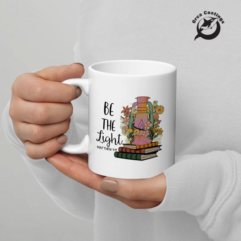 Tailorly White Ceramic 11 oz Mug - Be The Light Matthew 5 14 Vintage Oil Lamp Resting Atop Stacked Books Surrounded By Wildflowers Lantern